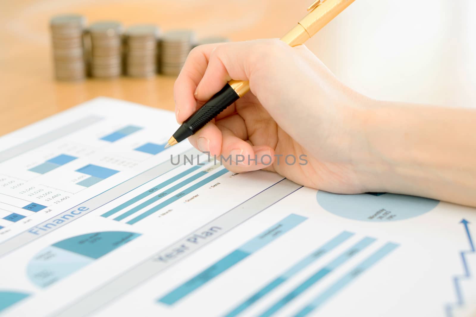 Businesswoman Analyzing Financial Graph With Coins  by ekachailo