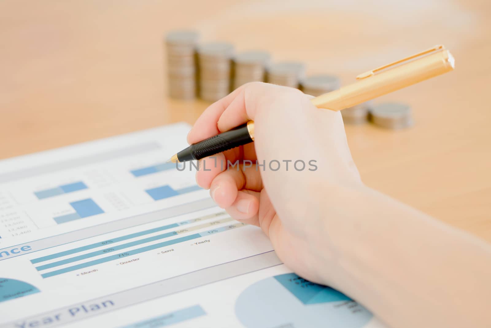 Businesswoman Analyzing Financial Graph With Coins  by ekachailo