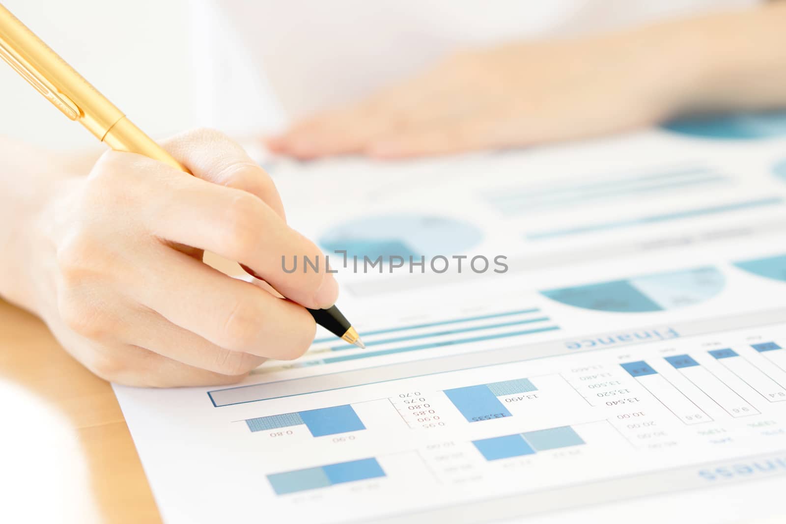 Businesswoman holding a pen and analyze data by ekachailo