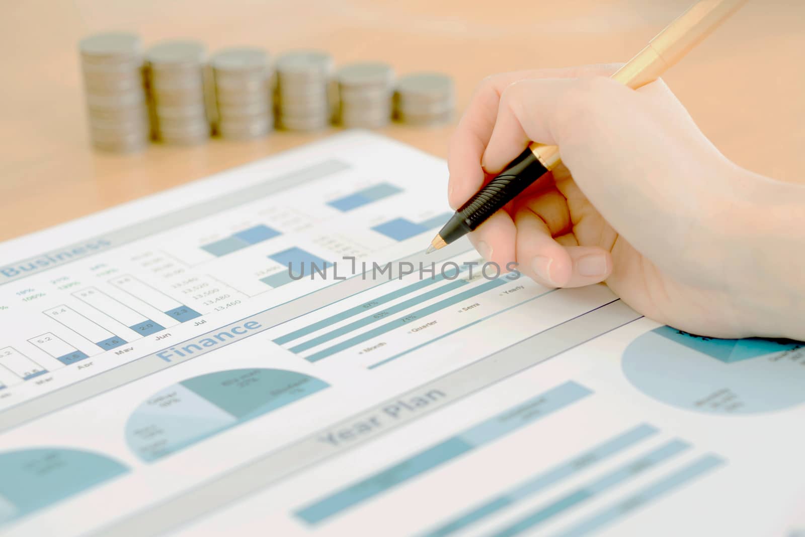 Businesswoman Analyzing Financial Graph With Coins  by ekachailo