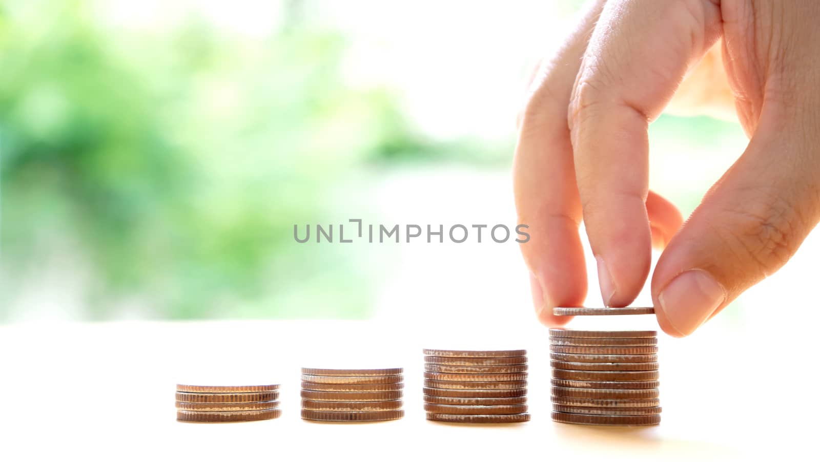 Close up of female hand stacking coins  by ekachailo