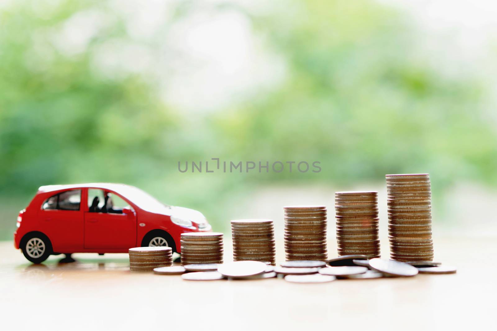 Stacks of giant silver coins next to a new red car  by ekachailo