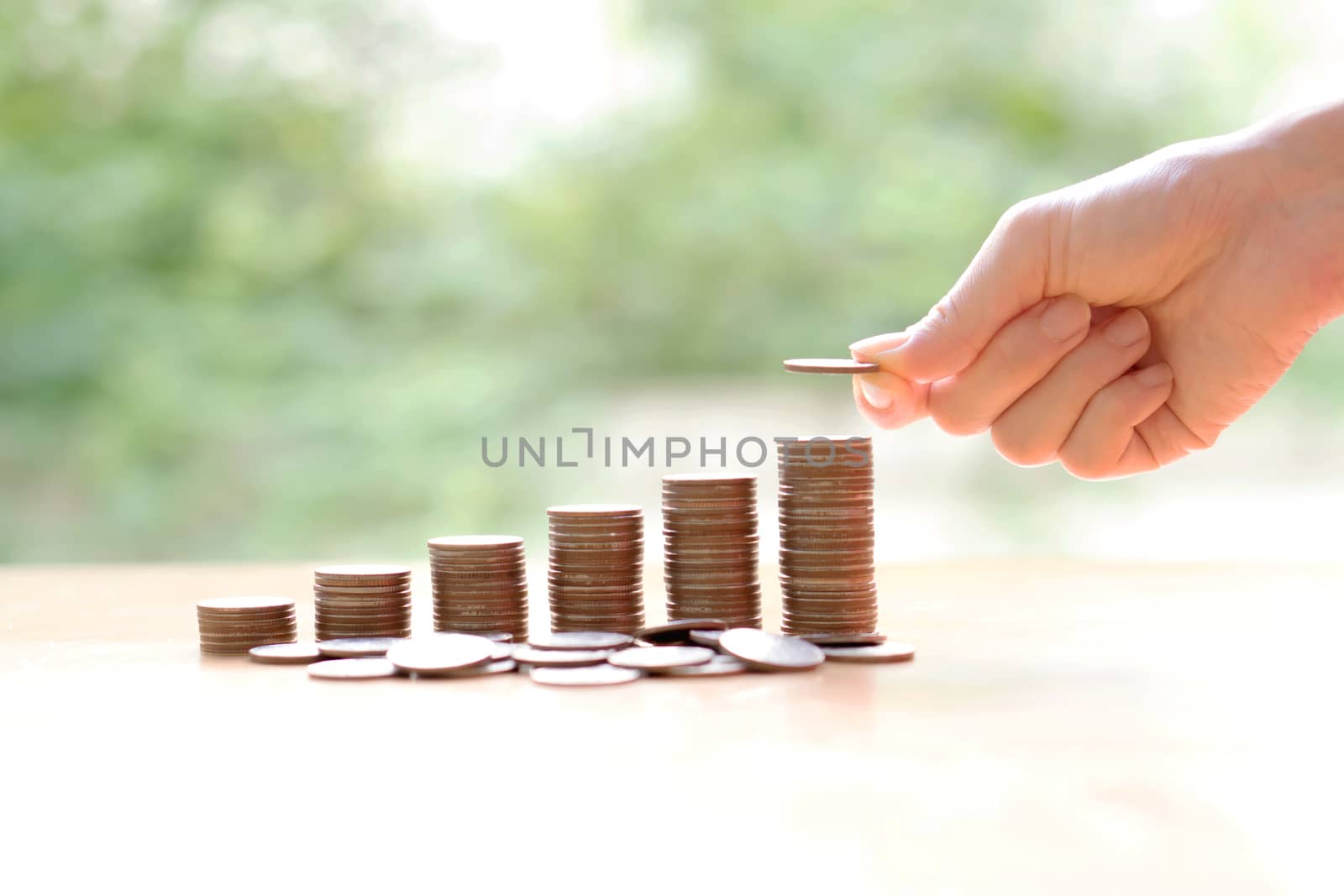Hand giving coins into stack, business and finance concept