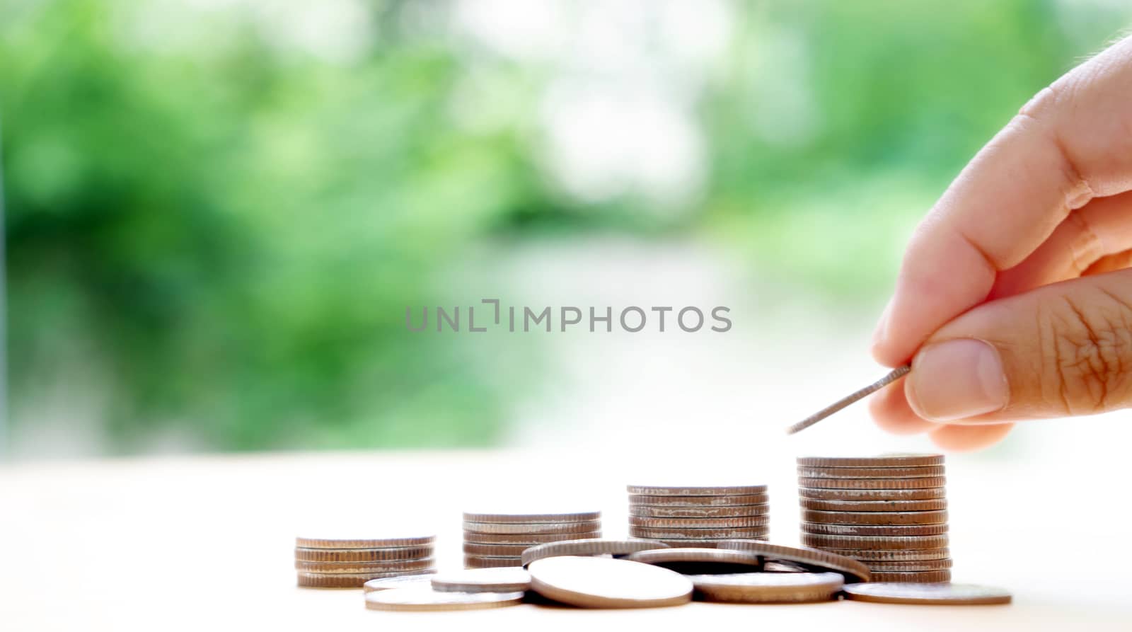 Close up of female hand stacking coins 