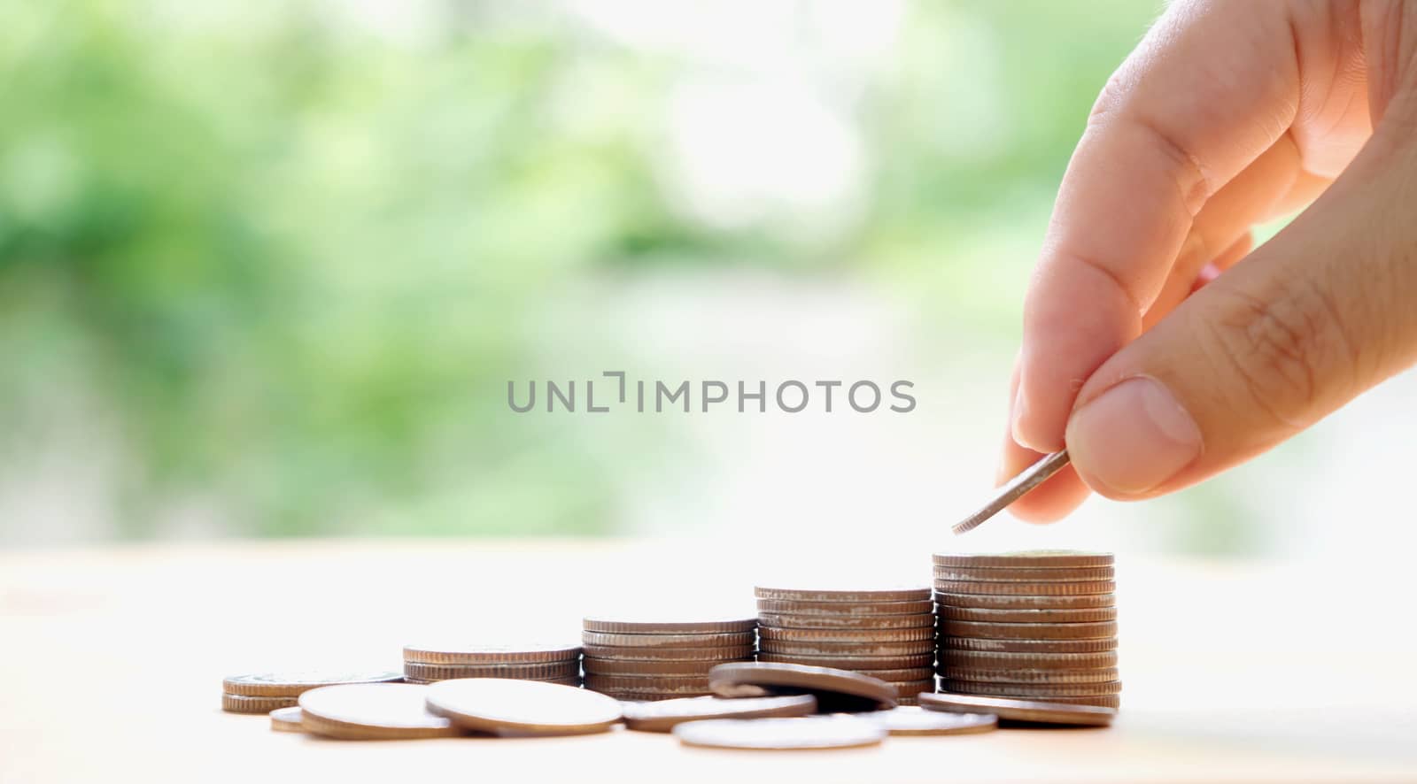 Close up of female hand stacking coins 