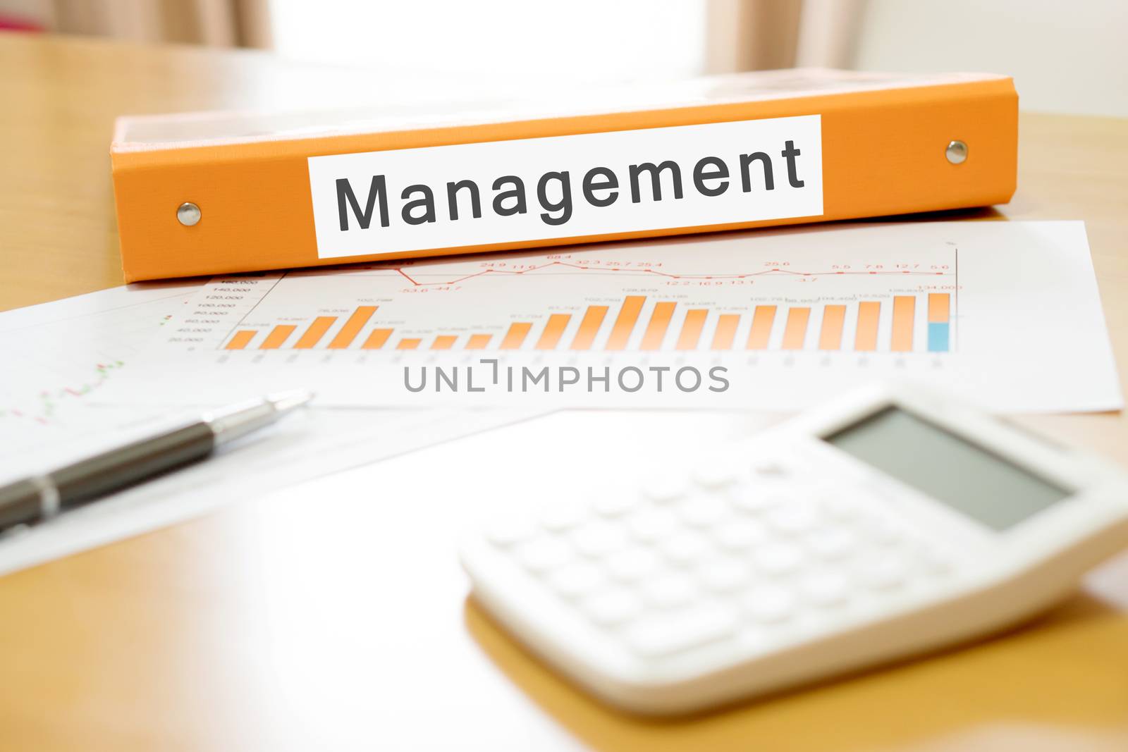 Orange  binder debtor on desk in the office with calculator and pen