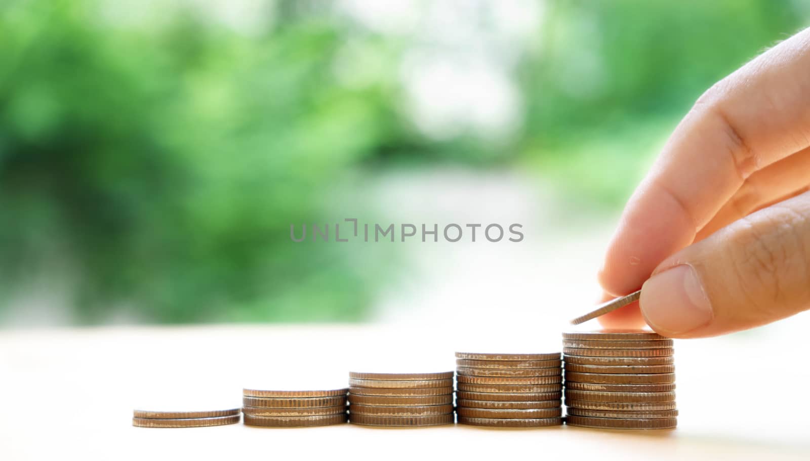 Close up of female hand stacking coins 