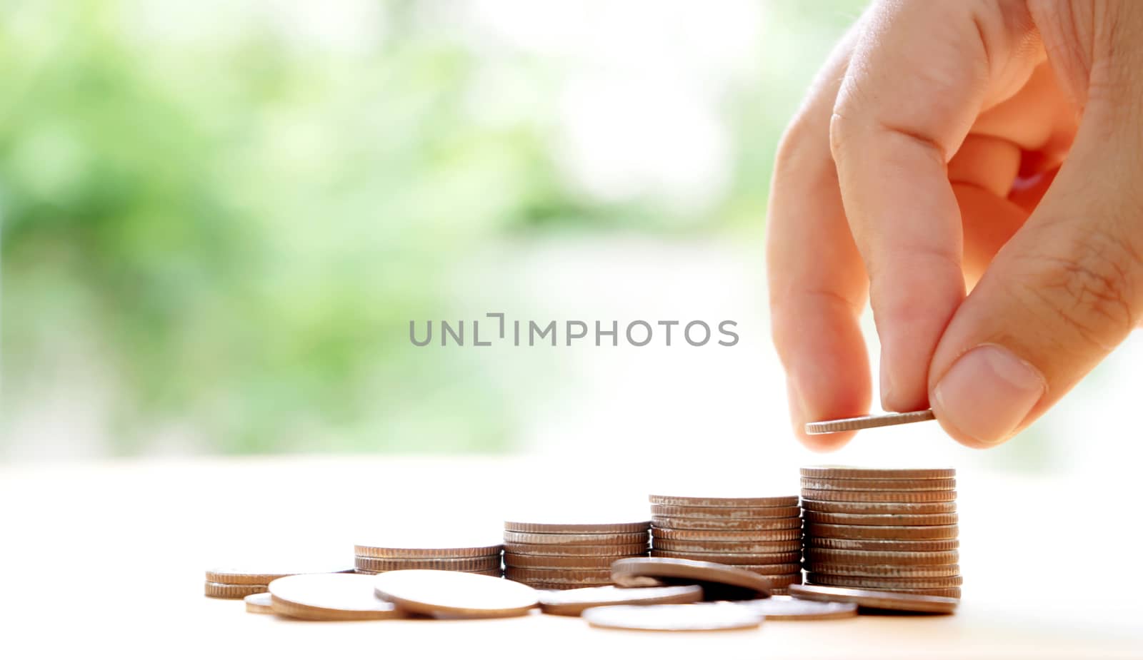 Close up of female hand stacking coins 