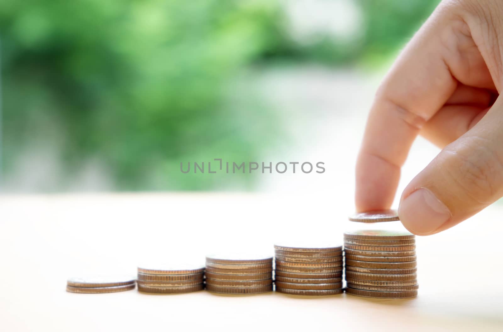 Close up of female hand stacking coins  by ekachailo