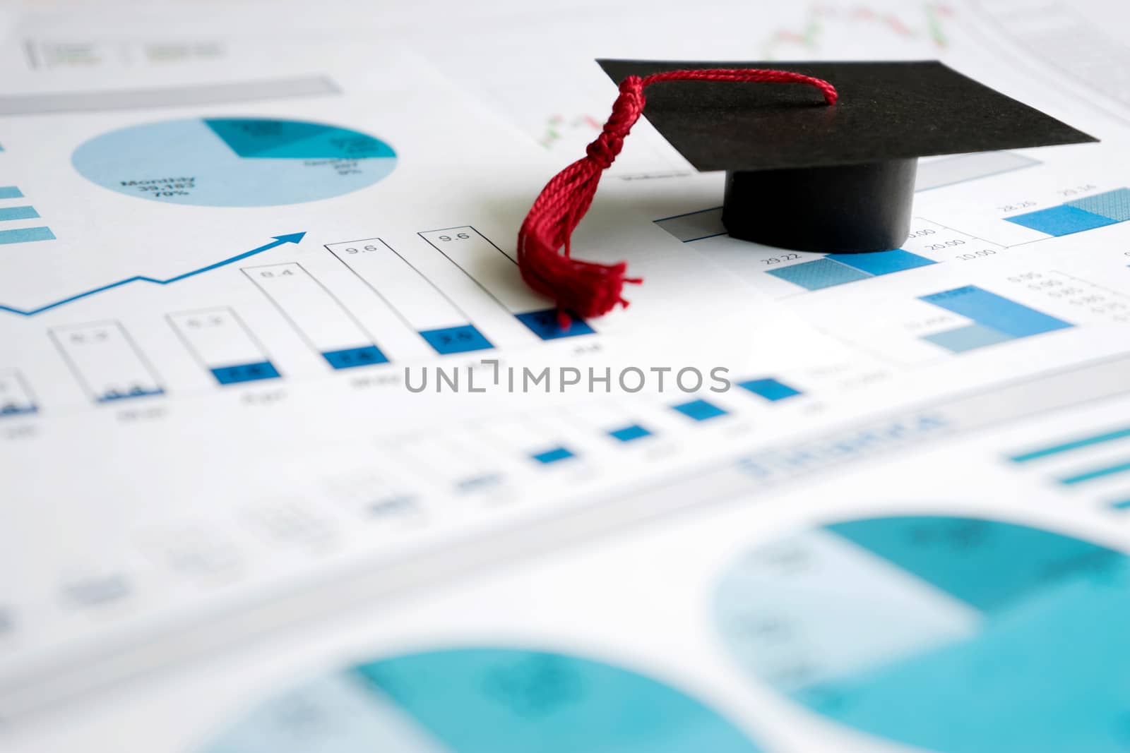 graduation caps on blue graphs and charts printed by ekachailo