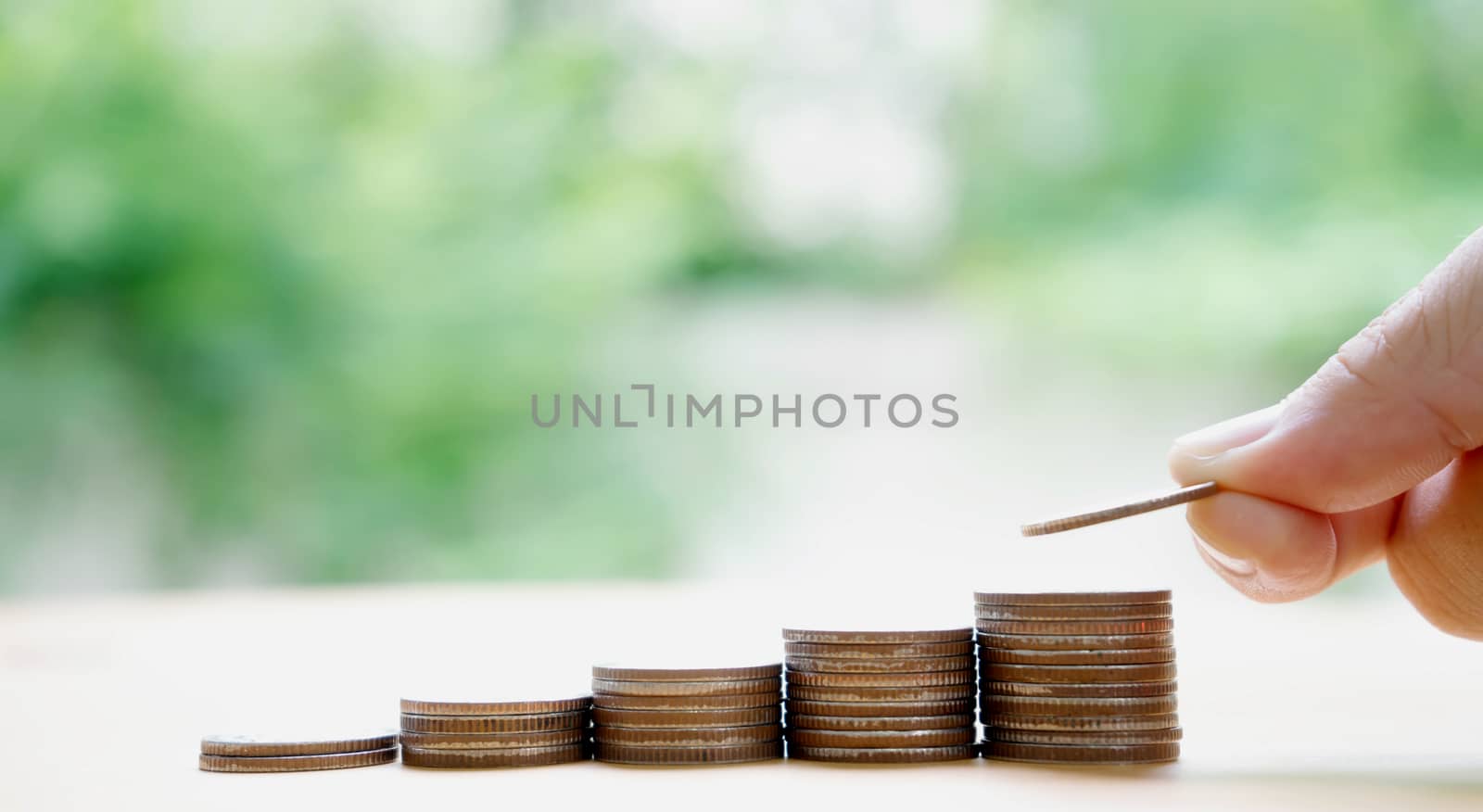 Close up of female hand stacking coins  by ekachailo