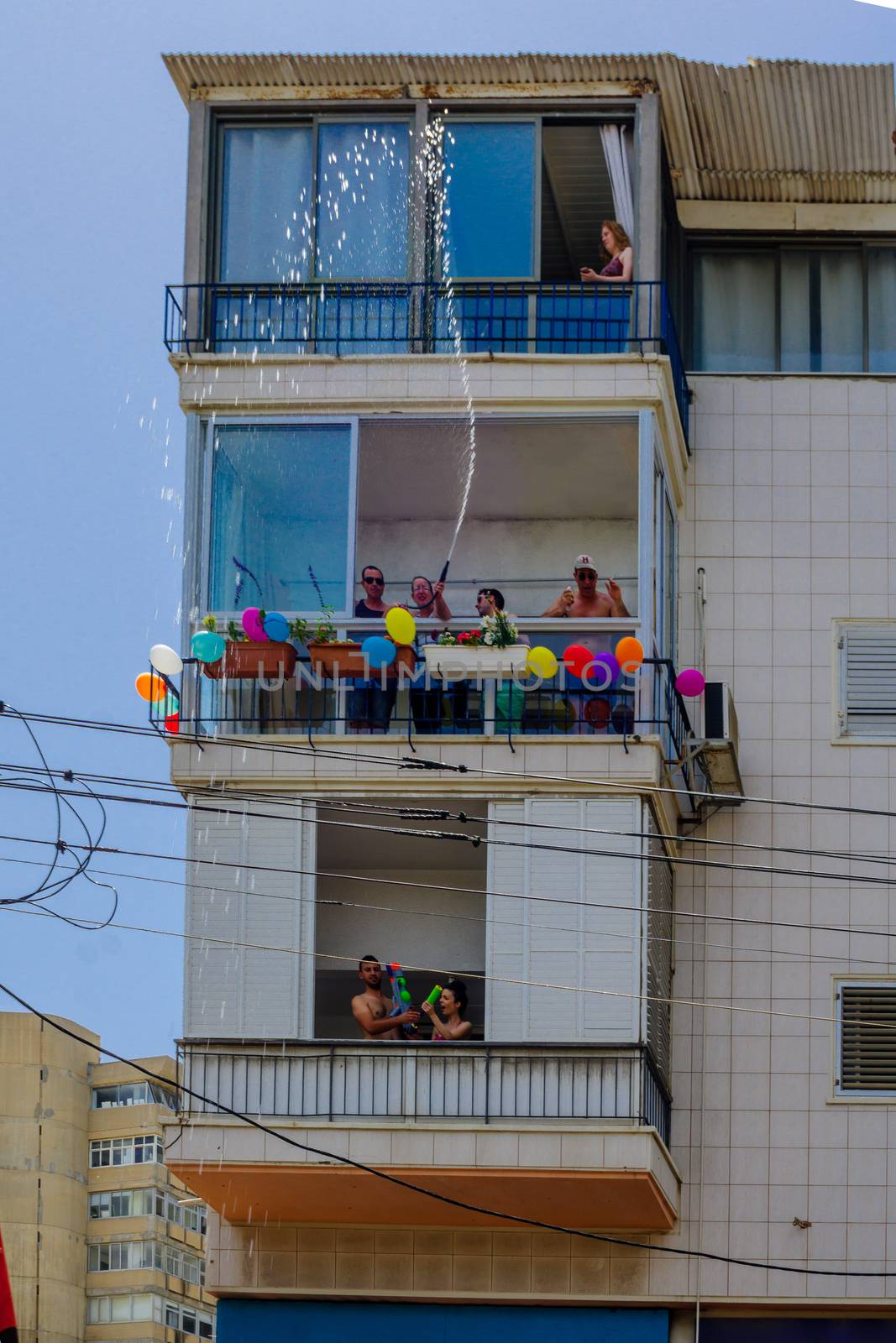 TEL-AVIV, ISRAEL - JUNE 03, 2016: Spectators cool the crowd with water, in the Pride Parade in the streets of Tel-Aviv, Israel. Its part of an annual event of the LGBT community