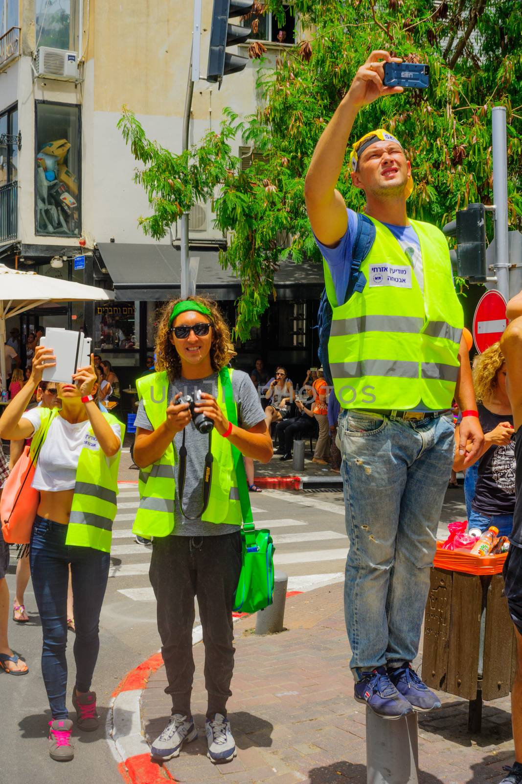 TEL-AVIV, ISRAEL - JUNE 03, 2016: Security guards make a break and take photos of the Pride Parade in the streets of Tel-Aviv, Israel. Its part of an annual event of the LGBT community