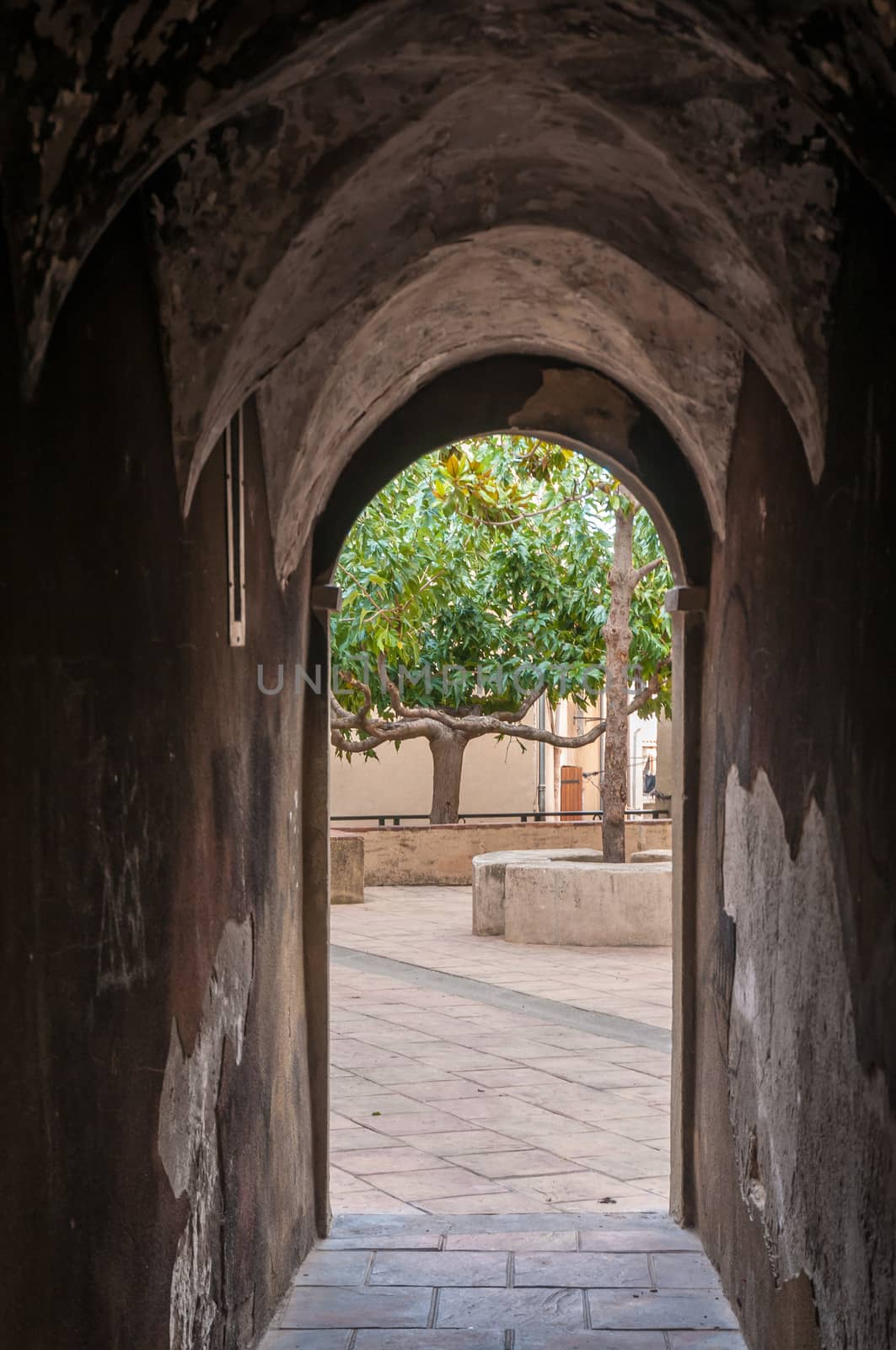 View of a little narrow street with an arch in the town of Brignoles in Provence, south of France