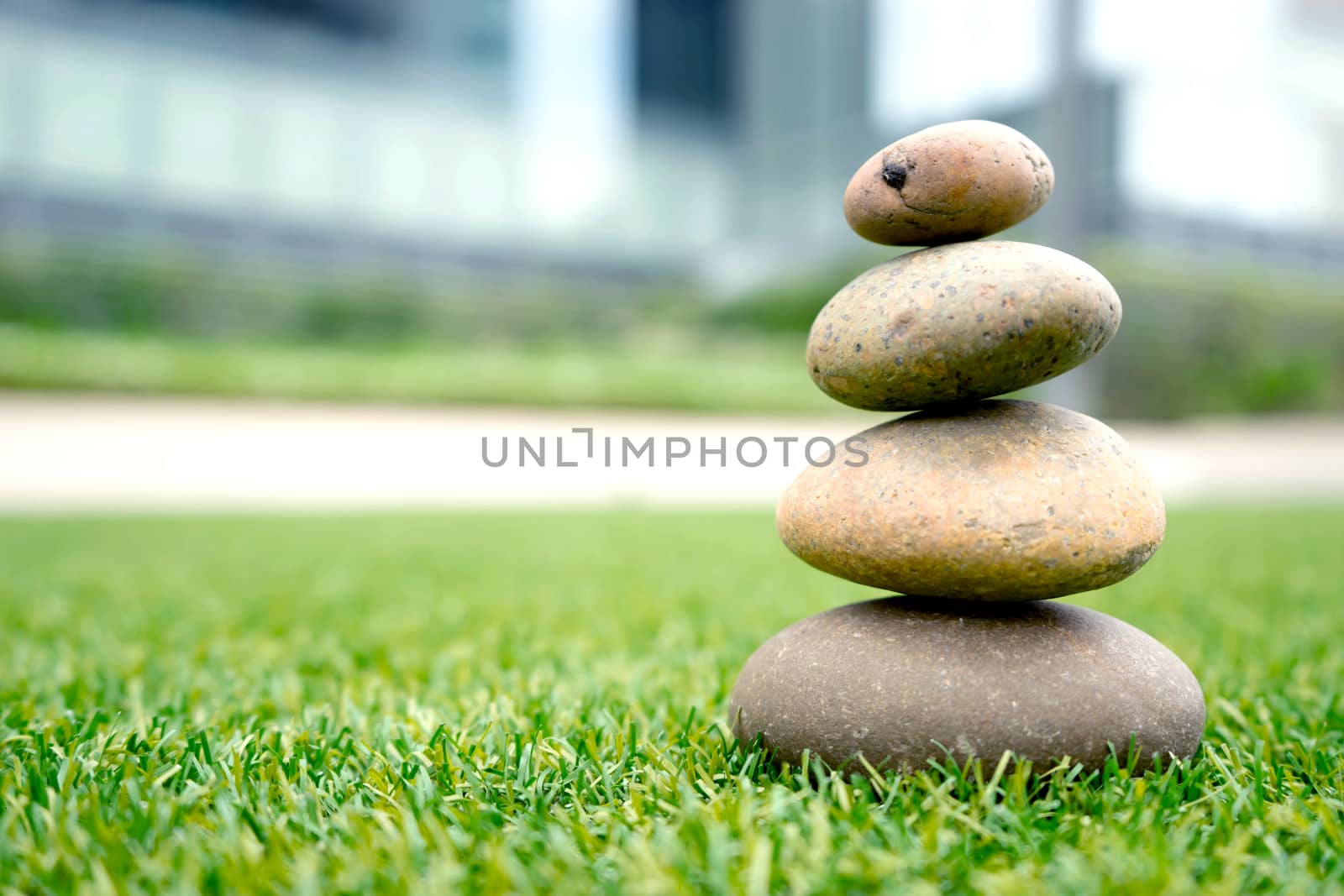 stones stacked up on grass by ekachailo