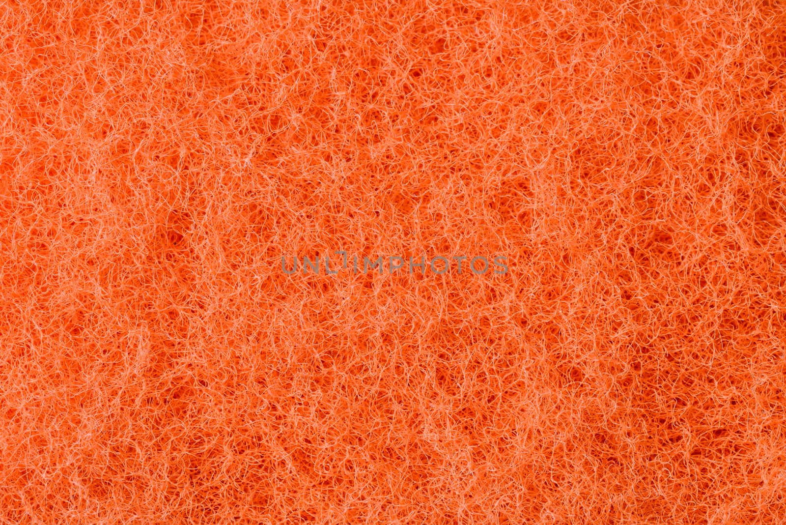 Macro of orange synthetic sponge texture, scrub side