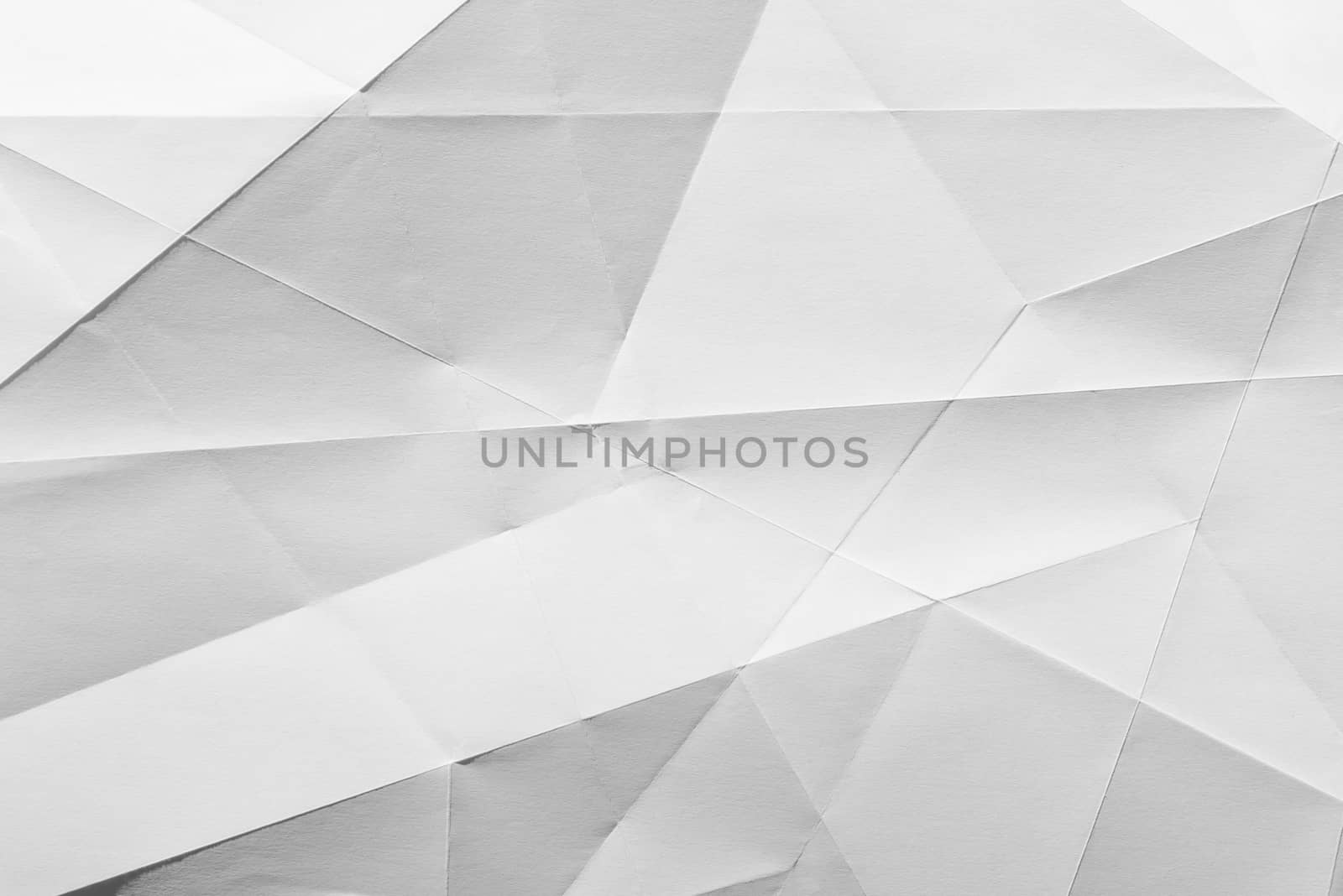 White folded sheet of paper showing an abstract texture design under the light grazing. Good to use as background