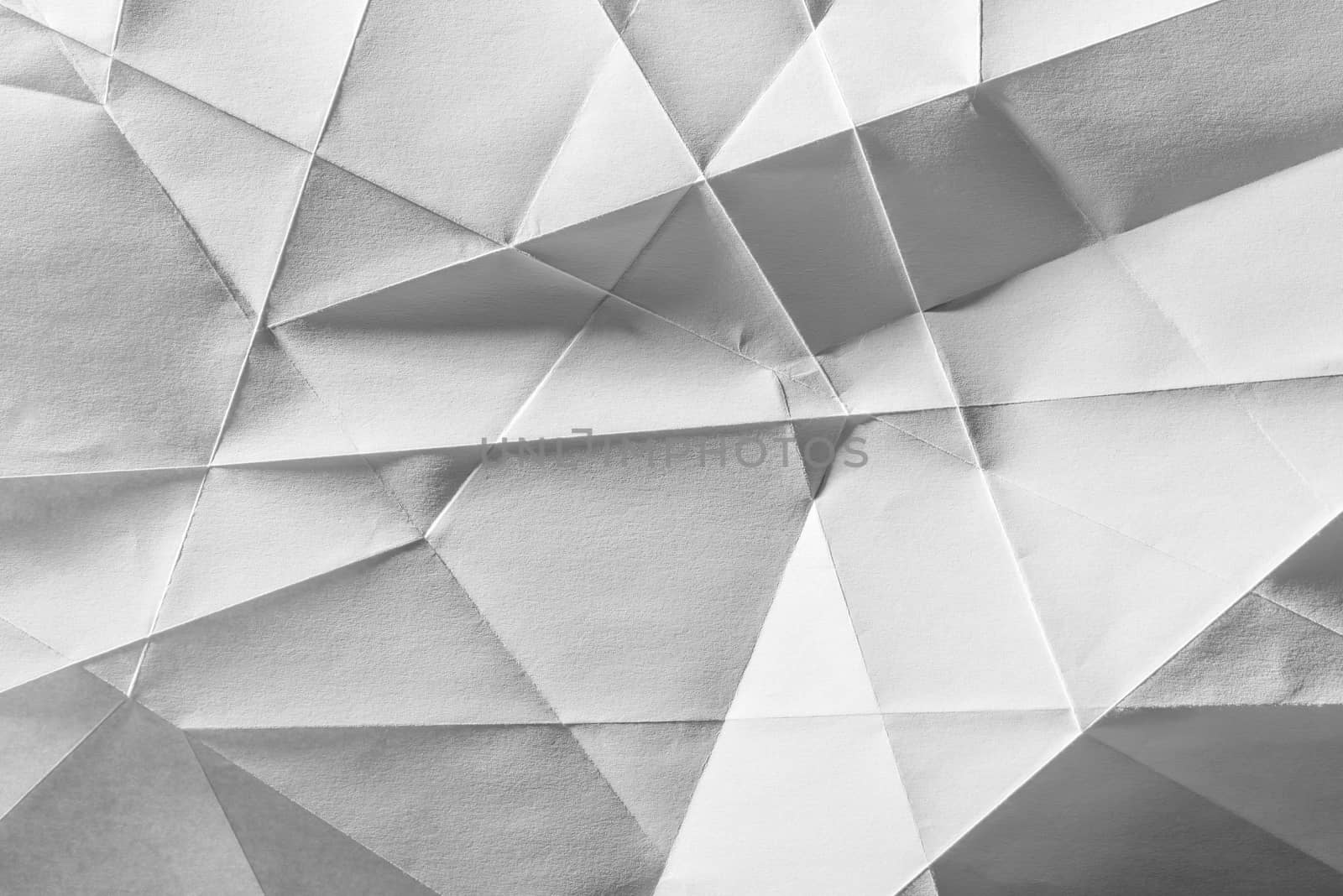 White folded sheet of paper showing an abstract texture design under the light grazing. Good to use as background