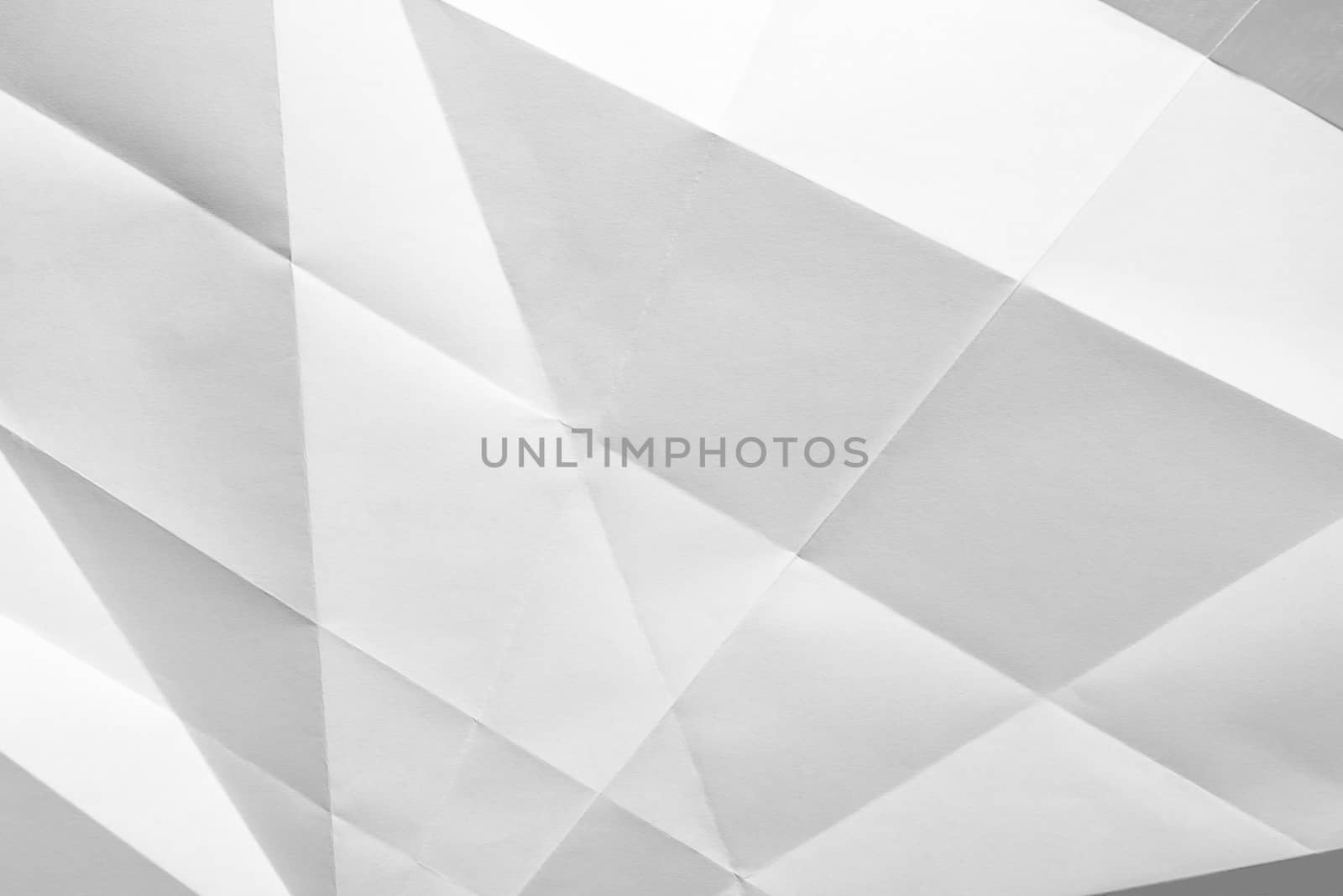 White folded sheet of paper showing an abstract texture design under the light grazing. Good to use as background