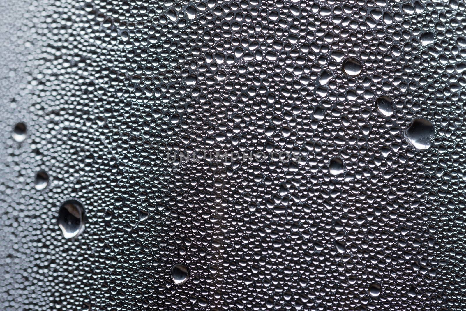 Many little water drops due to condensation on a plastic bottle curved surface