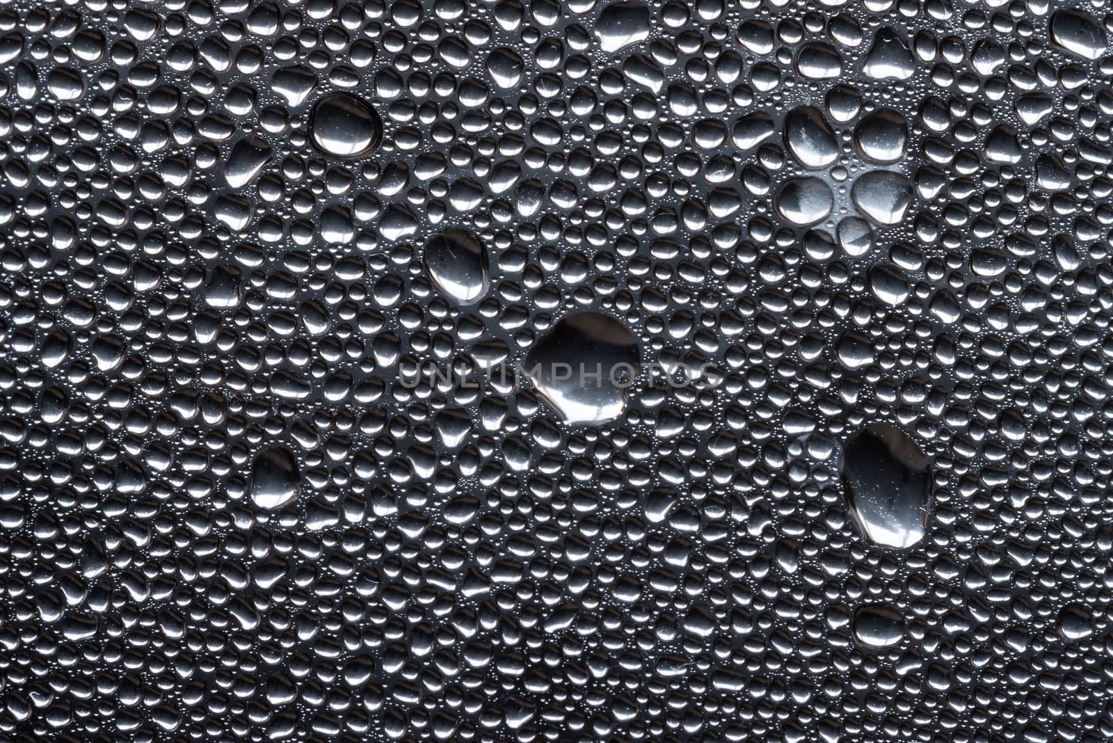 Many little water drops due to condensation on a plastic bottle curved surface