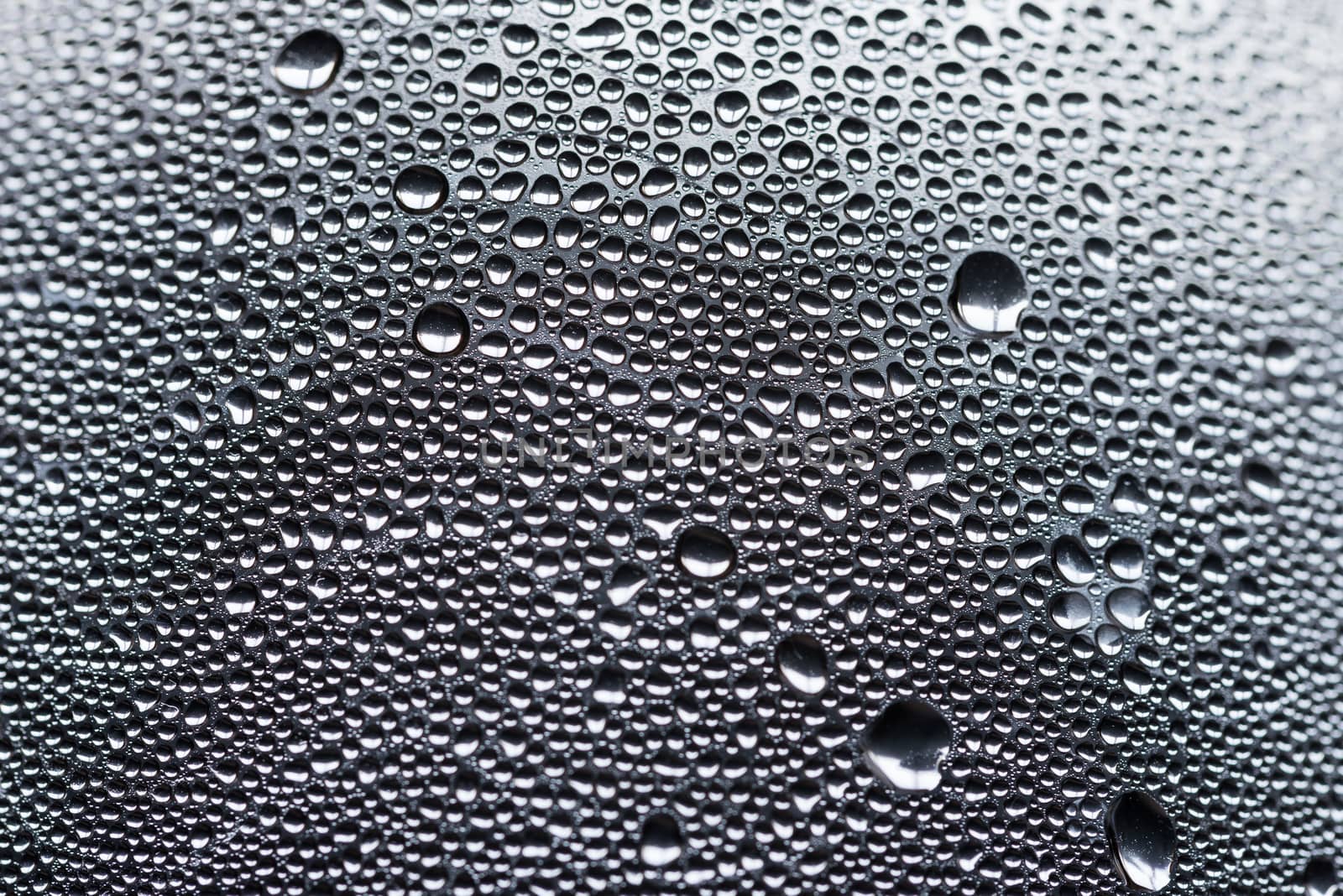 Many little water drops due to condensation on a plastic bottle curved surface