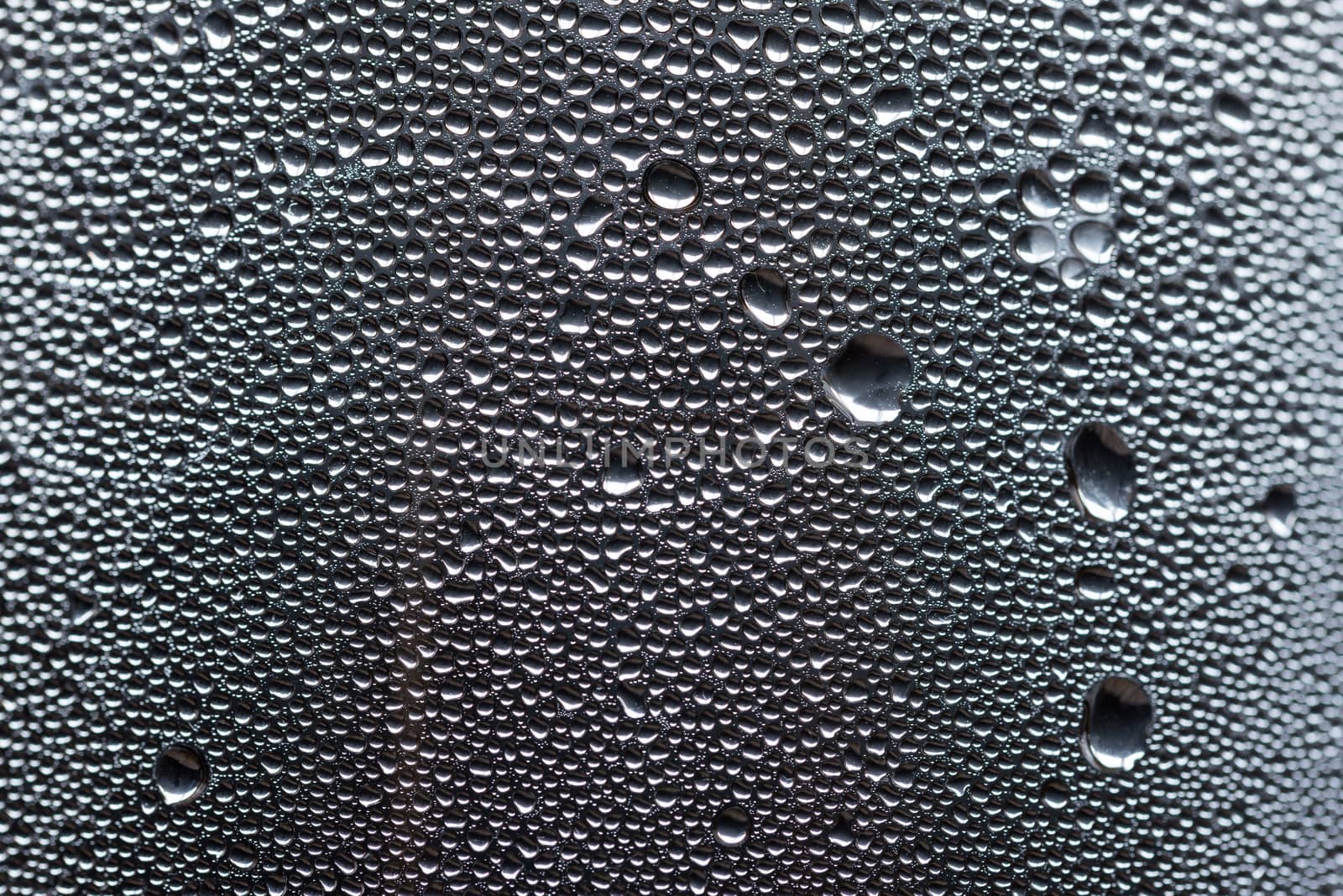 Many little water drops due to condensation on a plastic bottle curved surface