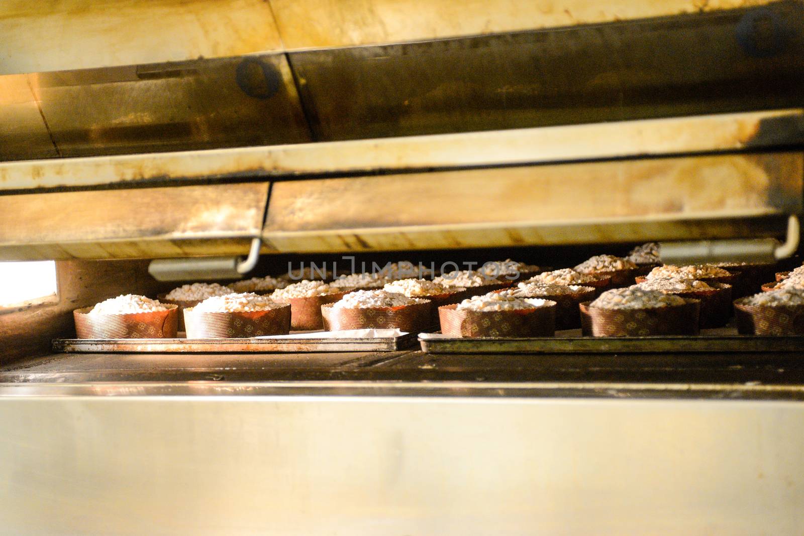 pastry chef in professional kitchen preparing and baking milanese panettone in christmas time. by verbano