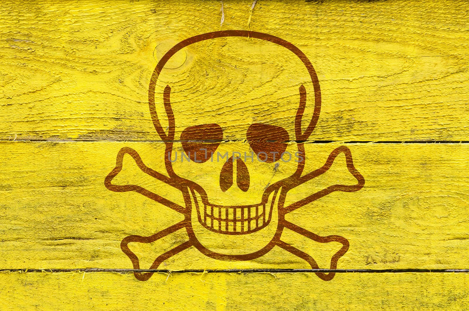 A skull as poison symbol on yellow painted pine planks