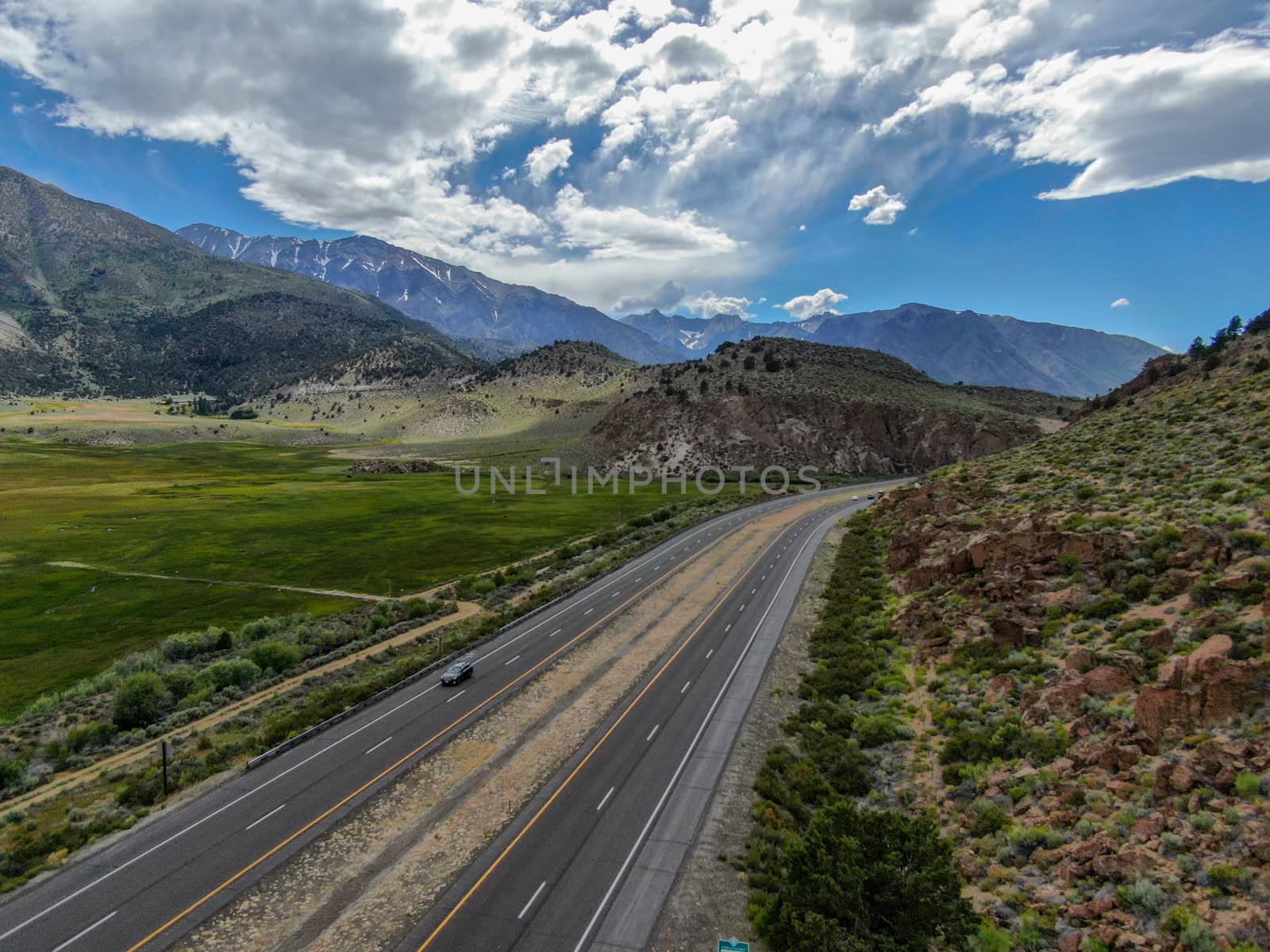 Aerial view of road in green land valley and mountain in Aspen Springs, Mono County California, USA