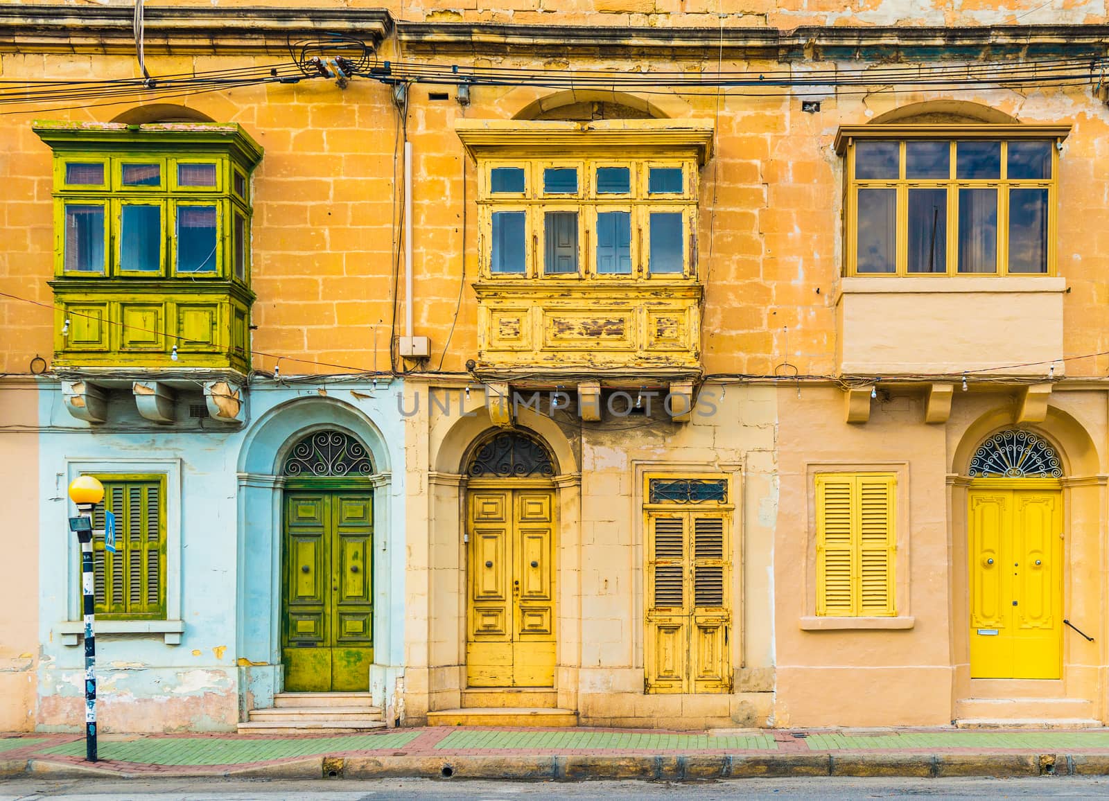 Malta, Valletta: Facade of a residential house with traditional maltese balconies. House made of yellow bricks in the street of Malta.