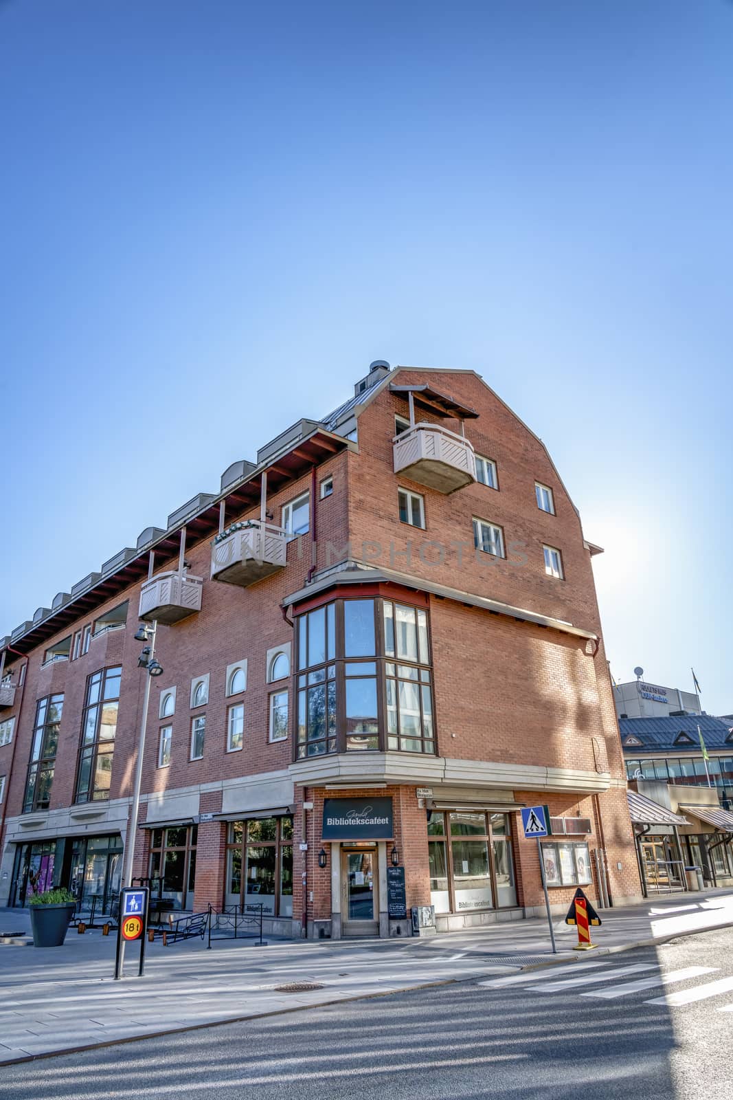 UMEA, SWEDEN - JUNE 10, 2020: The beautiful old building of famous Library Cafe in downtown of Umea city. Early sunny summer morning, Sun shine behind the top of house, blue sky. Vasterbotten county