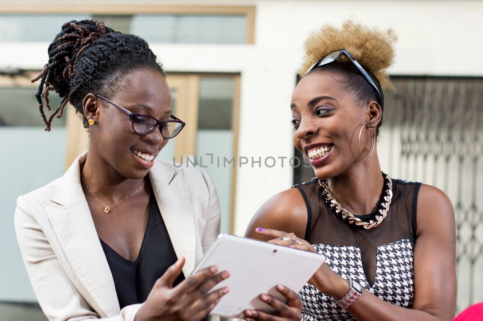 smiling businesswomen with tablet computers having discussion outdoor