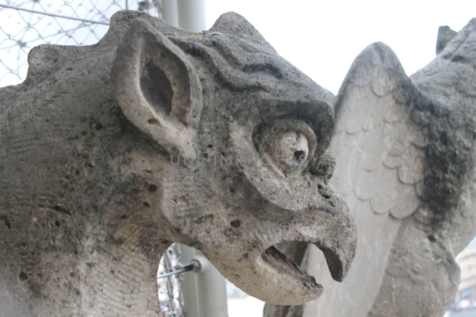 Gargoyle or chimera on the Cathedral of Notre Dame de Paris looks at the Eiffel Tower, Paris, France. Gargoyles are the Gothic landmarks in Paris. Vintage skyline of Paris with an old demon statue.