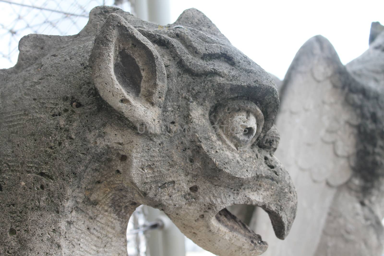 Gargoyle or chimera on the Cathedral of Notre Dame de Paris looks at the Eiffel Tower, Paris, France. Gargoyles are the Gothic landmarks in Paris. Vintage skyline of Paris with an old demon statue.