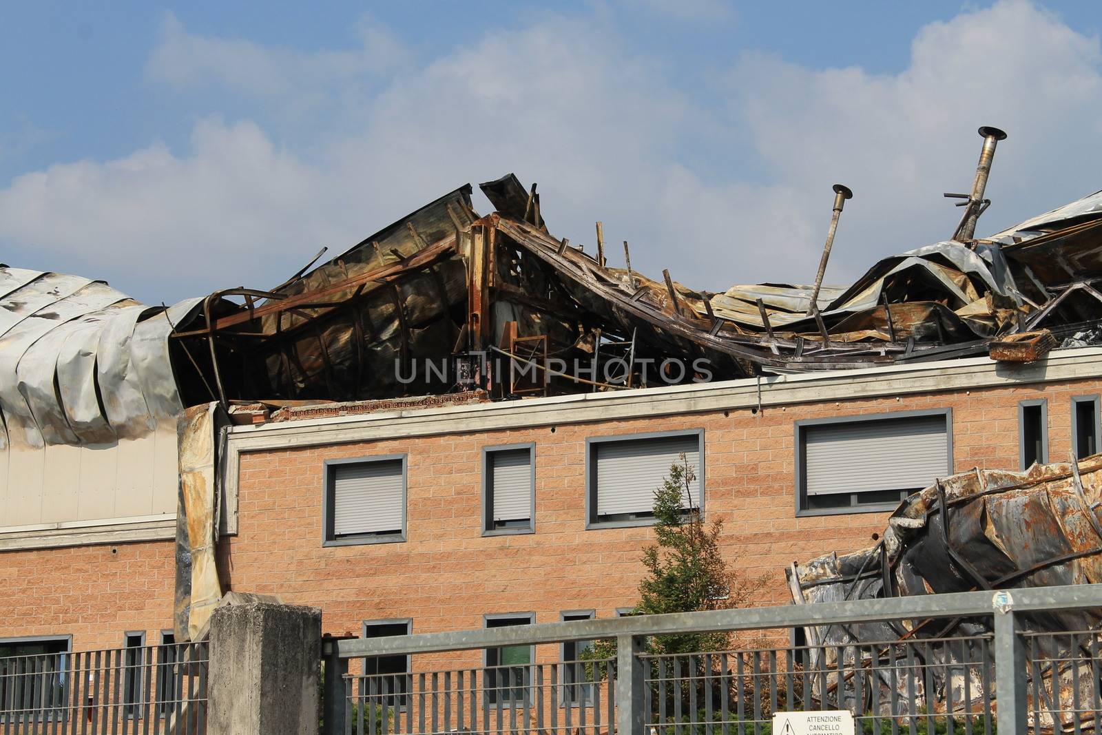 Facade of an industrial building after a fire against a blue sky