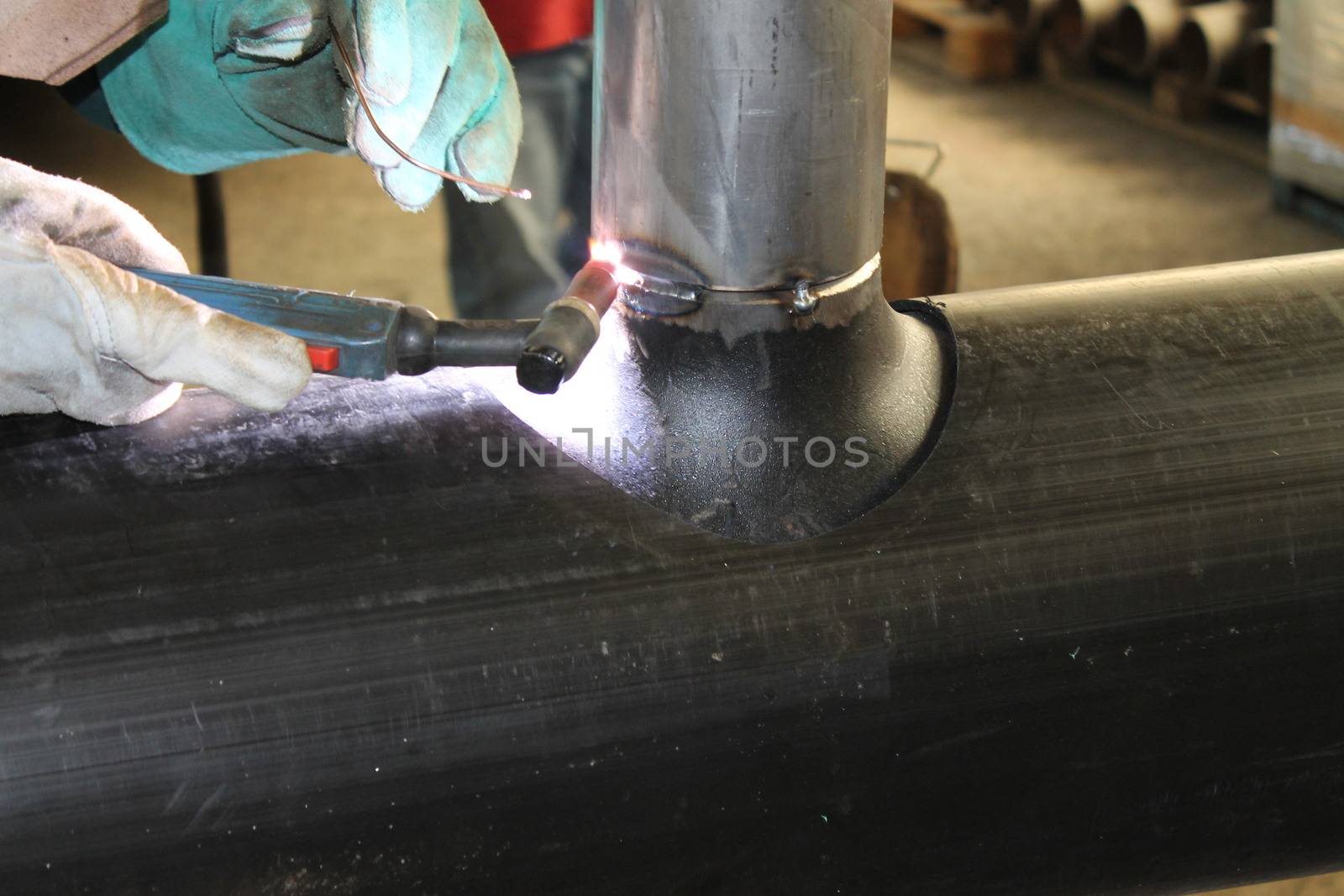 Welder Worker Performs Jump Welding. Worker Welder Performs Arc-Welding Process of Metal Structures. Flying Sparks From the Welding Machine. Welder Welds Metal Profiles for Second Floor Indoors