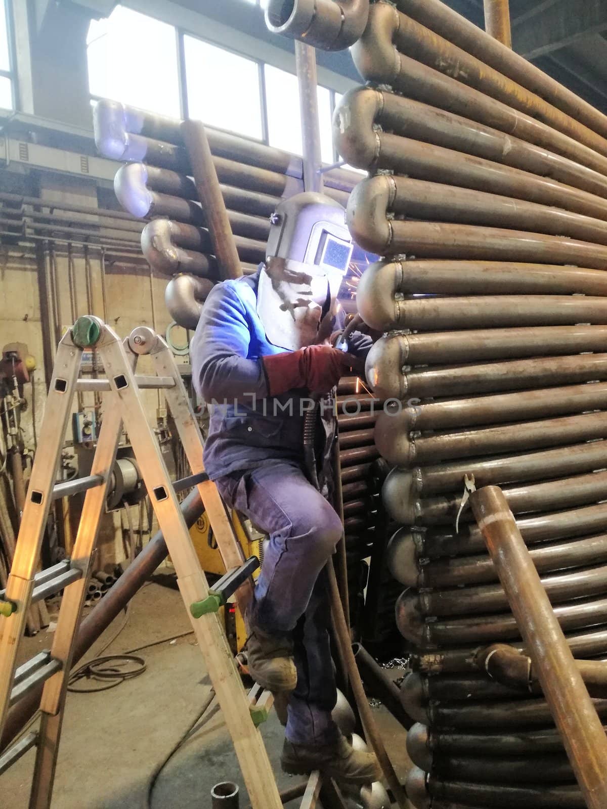 Welding with sparks by Process fluxed cored arc welding , Industrial steel welder part in factory welder Industrial automotive part in factory.