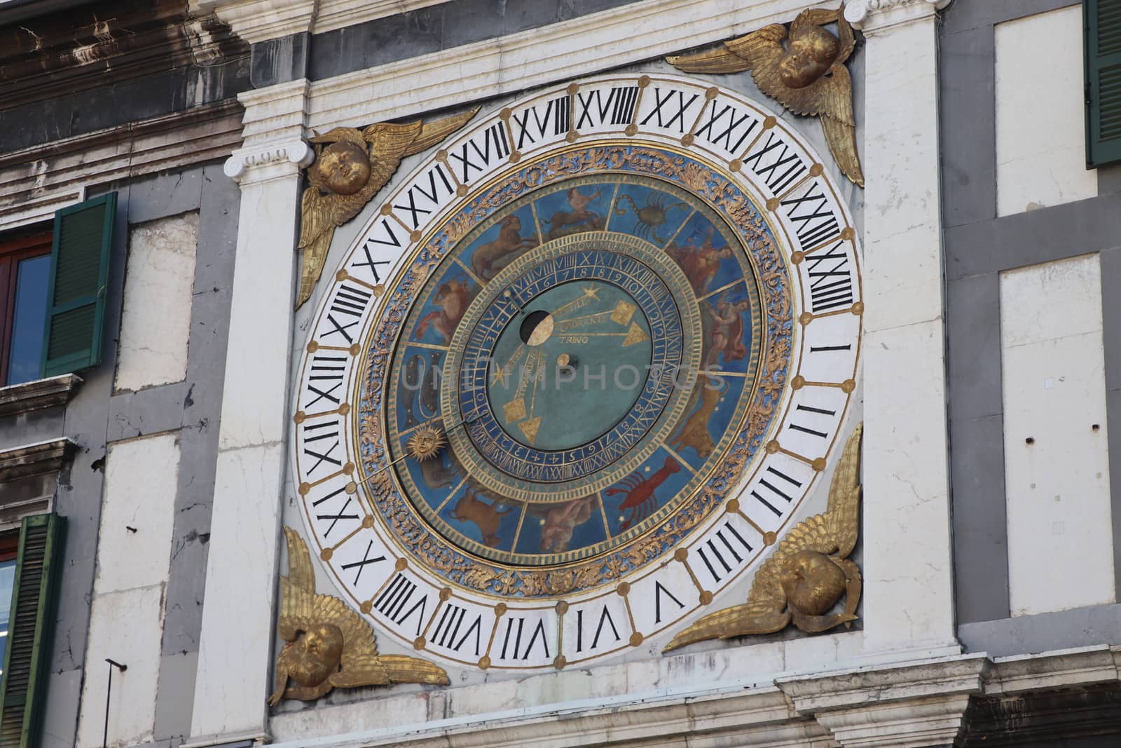 the clock tower with historical astronomical clock in Brescia, Italy