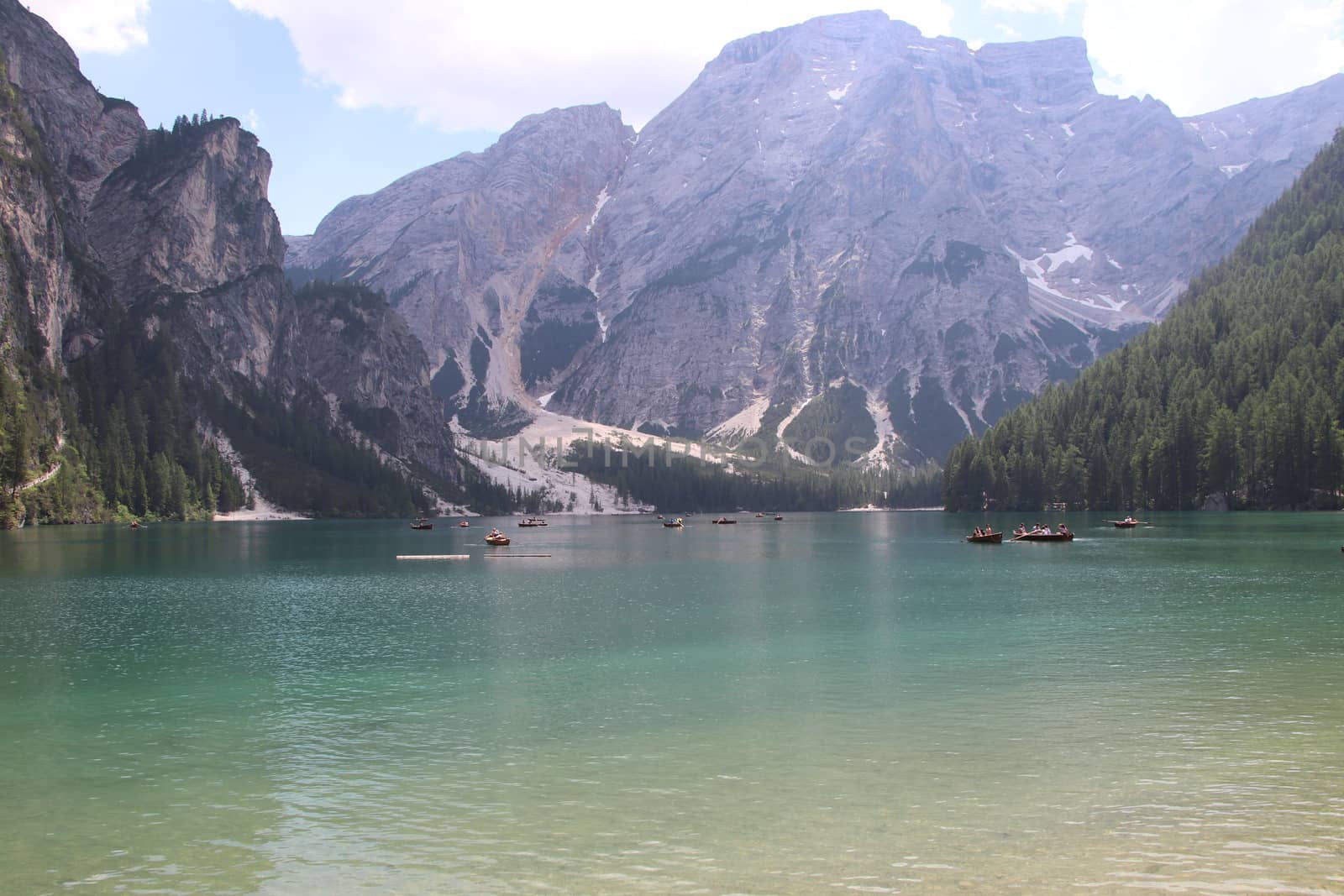 Braies Lake in Dolomites mountains forest trail in background, Sudtirol, Italy. Lake Braies is also known as Lago di Braies. The lake is surrounded by forest which are famous for scenic hiking trails.