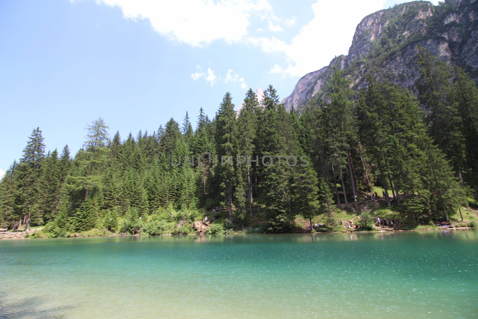 Braies Lake in Dolomites mountains forest trail in background, Sudtirol, Italy. Lake Braies is also known as Lago di Braies. The lake is surrounded by forest which are famous for scenic hiking trails.