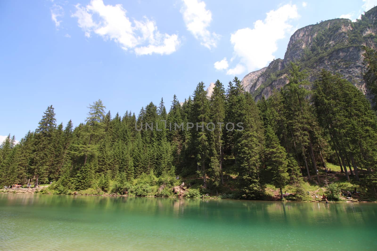 Braies Lake in Dolomites mountains forest trail in background, Sudtirol, Italy. Lake Braies is also known as Lago di Braies. The lake is surrounded by forest which are famous for scenic hiking trails.