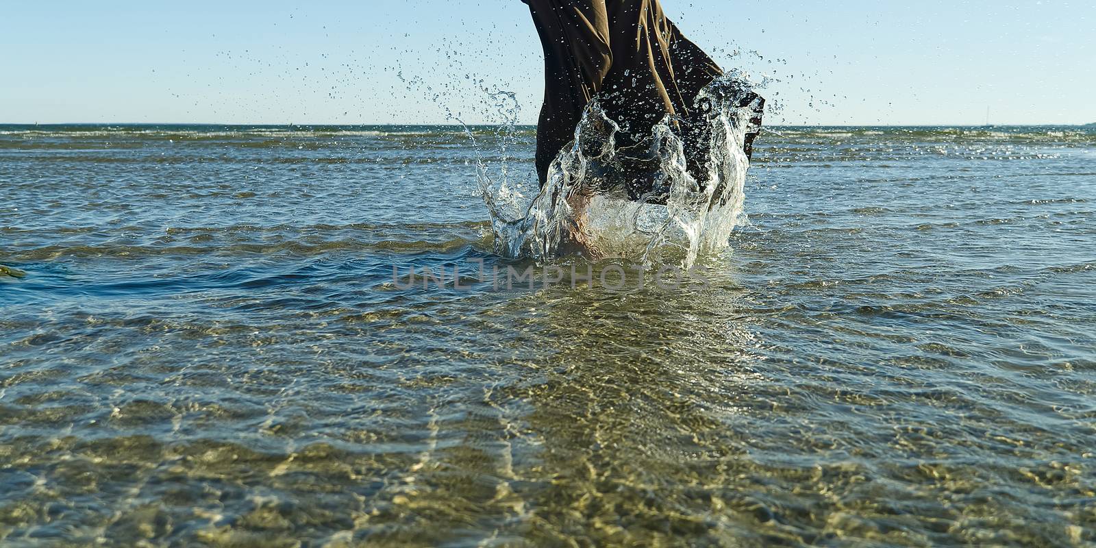 nice legs of a pretty girl walking in water. woman legs, walking on the beach. Legs of a beautiful young girl who runs towards the ocean. by PhotoTime