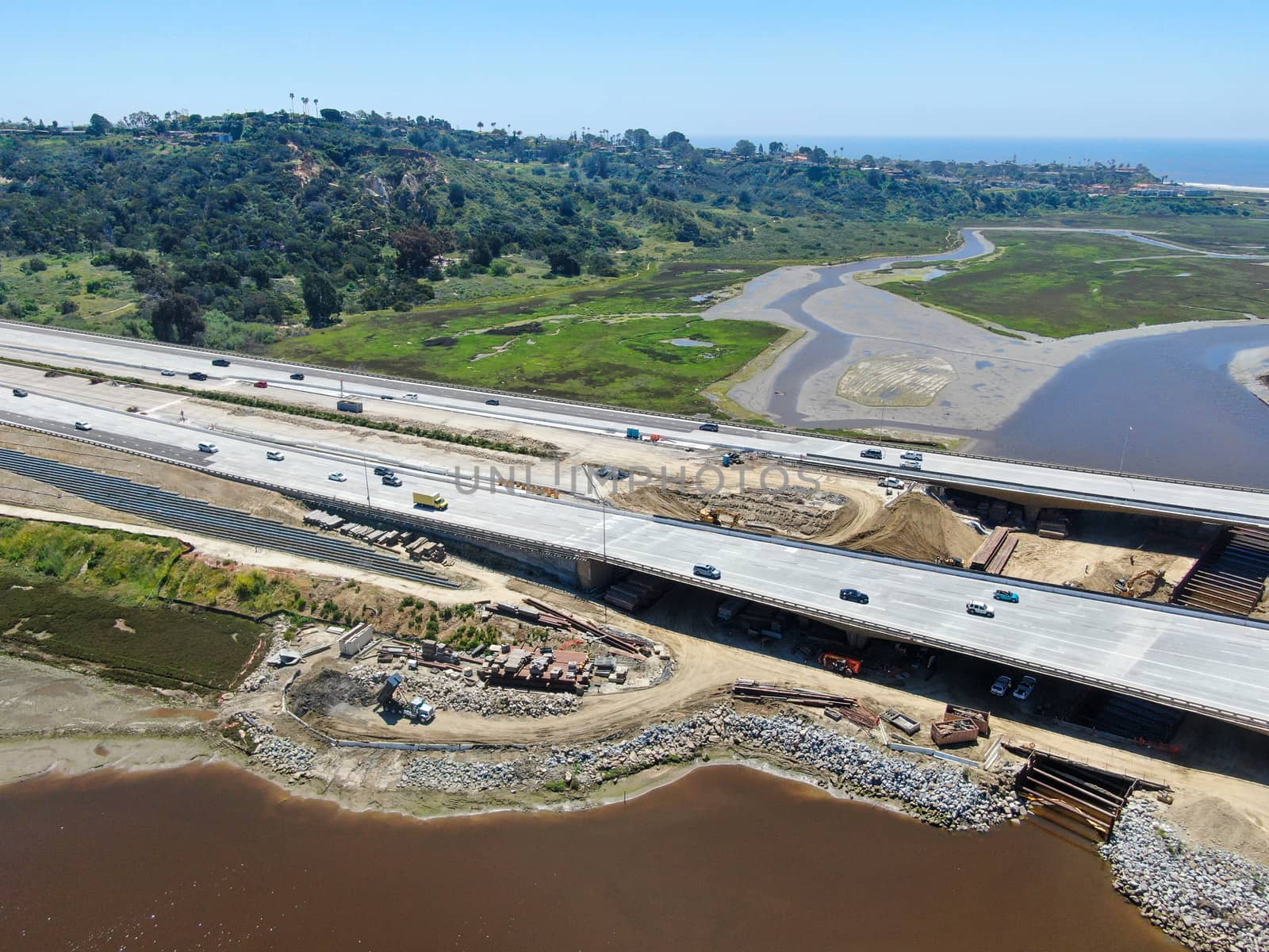 Aerial view of highway bridge construction over small river by Bonandbon
