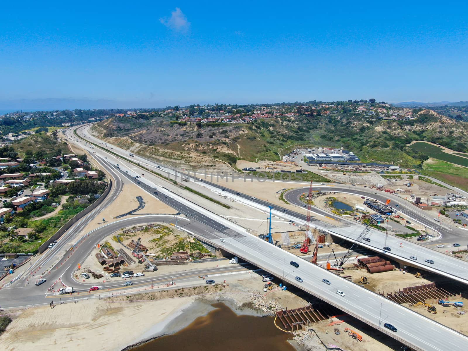 Aerial view of highway bridge construction over small river by Bonandbon