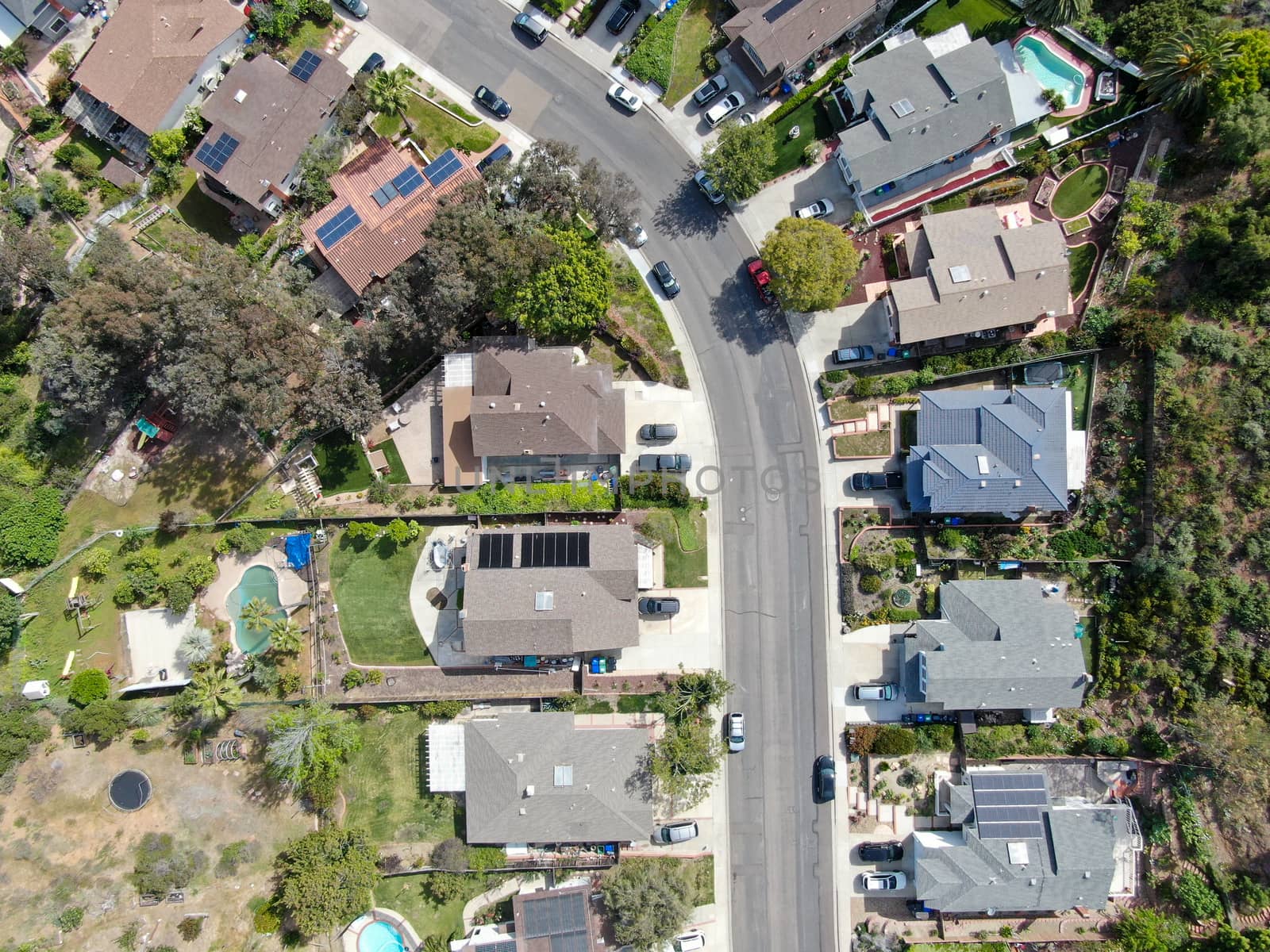 Aerial top view of upper middle class neighborhood street with residential house and swimming pool by Bonandbon