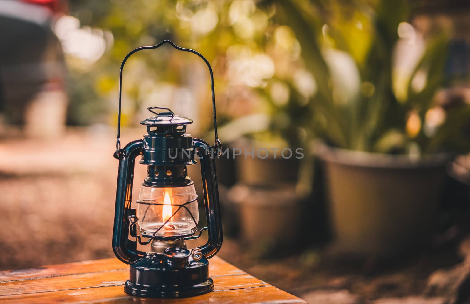 vintage latern hanging on the table in the evening by domonite