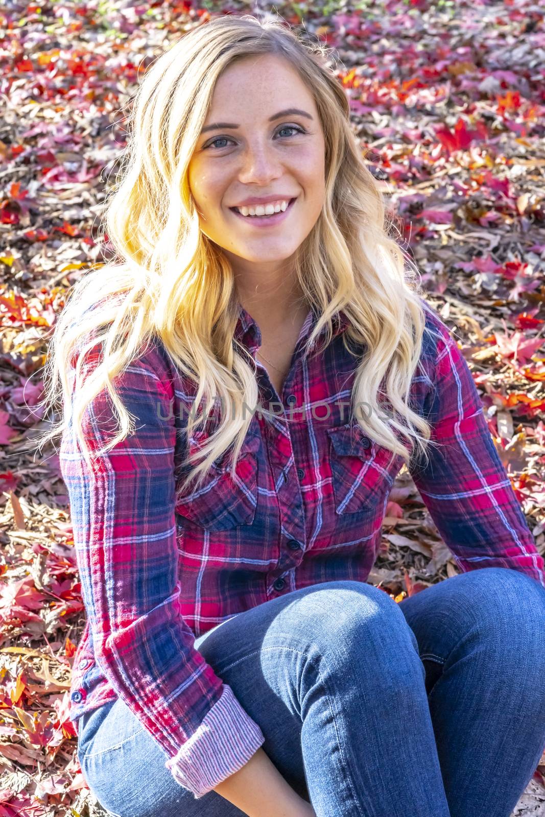 A gorgeous blonde model enjoys a Autumn day outdoors in a park