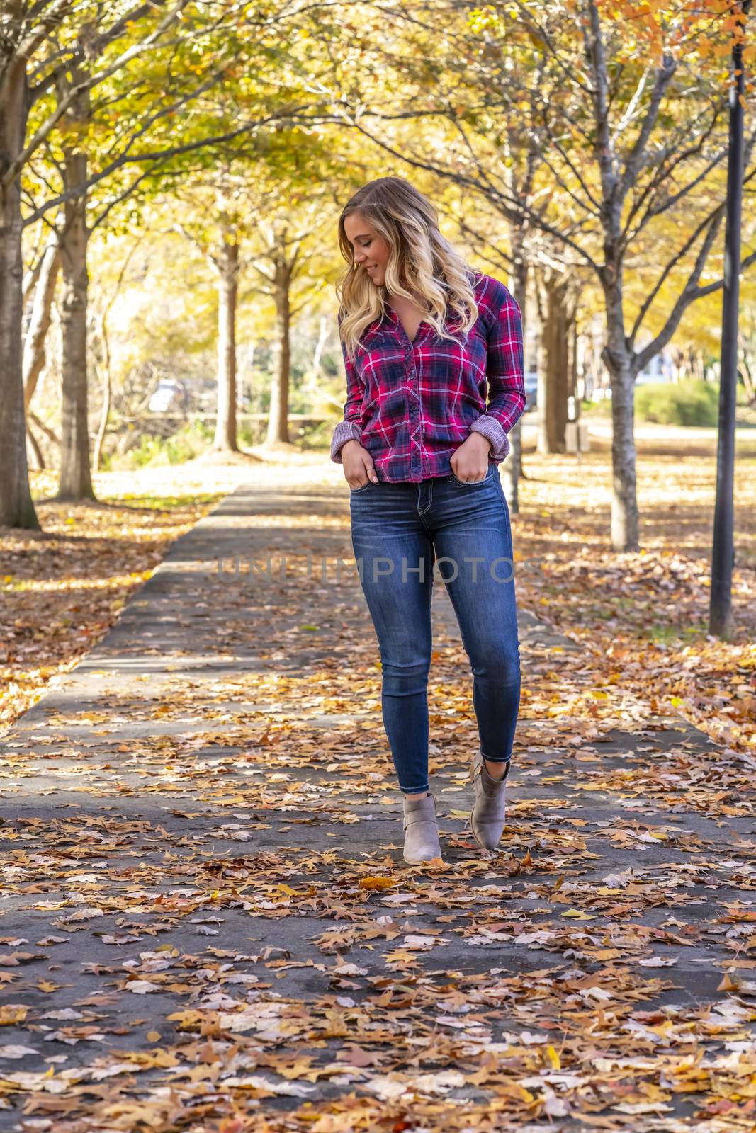 A gorgeous blonde model enjoys a Autumn day outdoors in a park