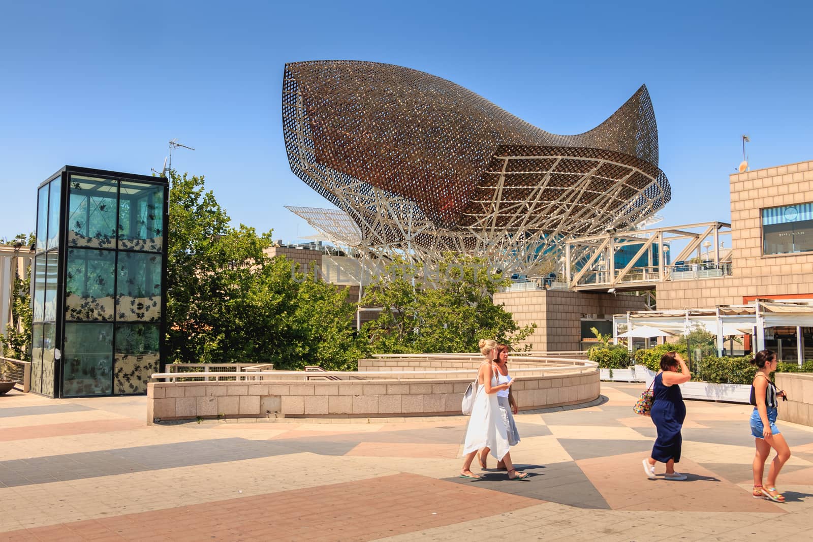 Barcelona, Spain - June 21, 2017 : in the middle of the day, tourists stroll in front of the fish of the American architect Frank Gehry built on the occasion of the 1992 summer Olympics